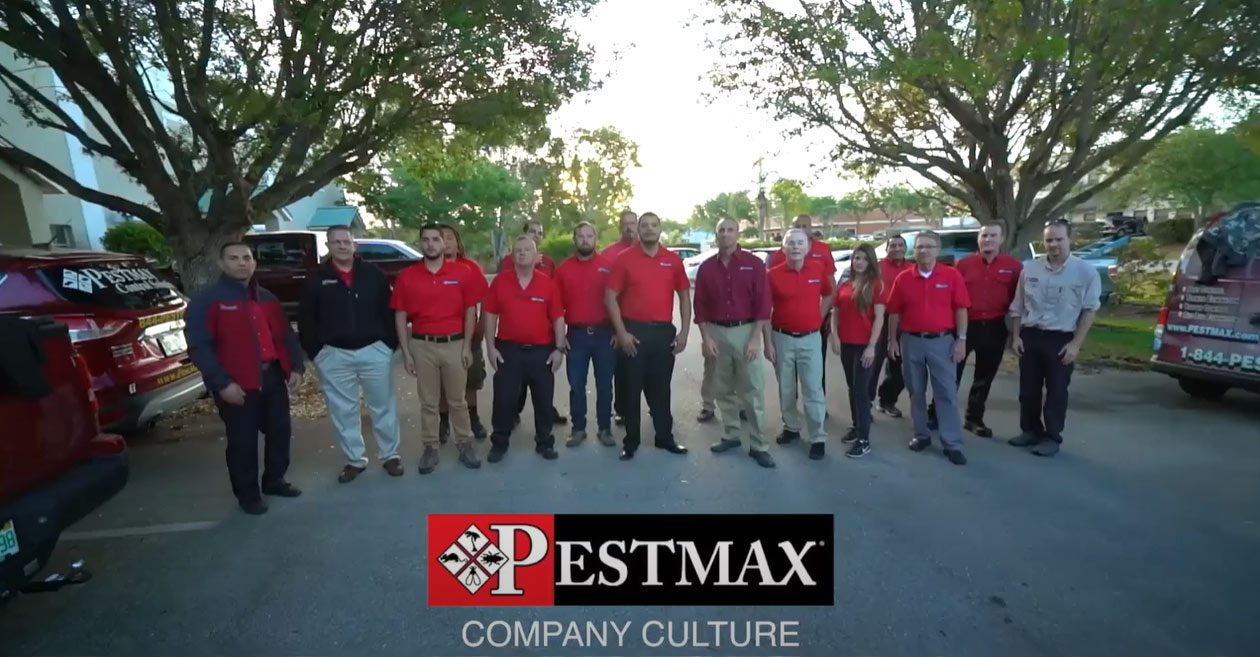 The PestMax team in red polos with branded trucks